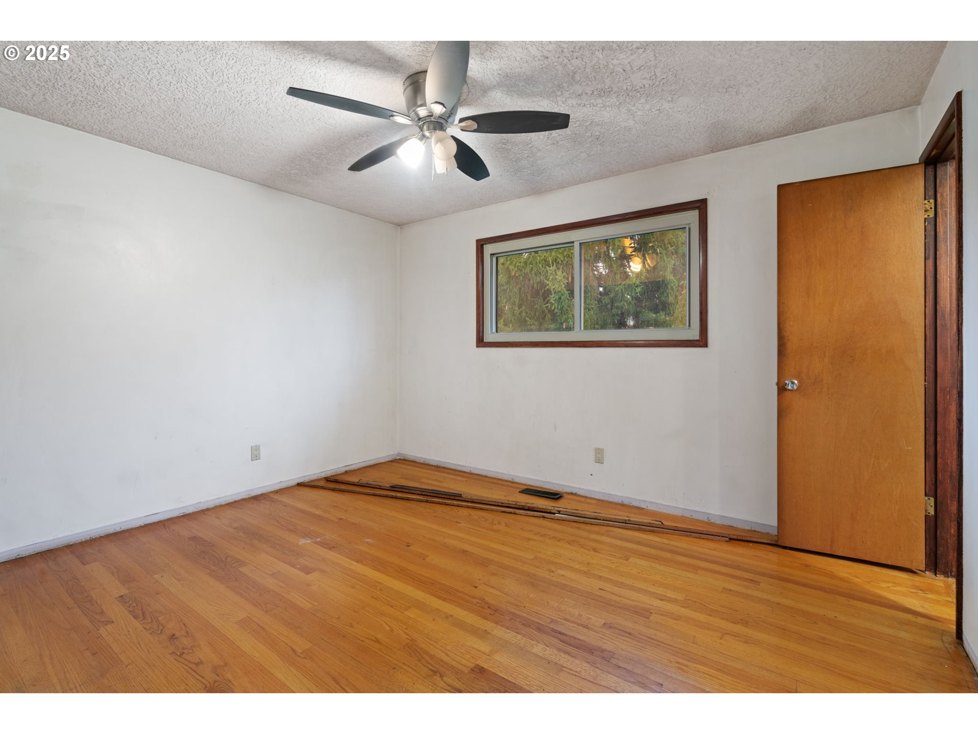 13122 Northeast Morris Court Portland, OR 97230 - Photo 16 of 38 a view of an empty room with wooden floor and a window