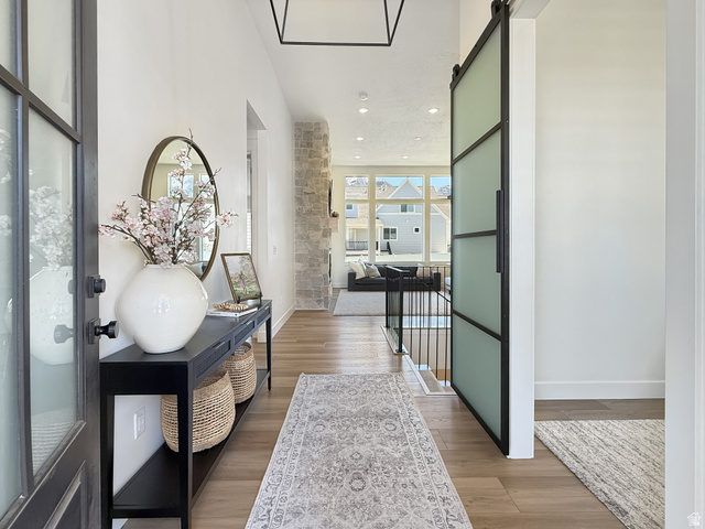916 Rocky Mountain Way Elk Ridge, UT 84651 - Photo 5 of 54 Corridor featuring light wood-style floors, a barn door, and recessed lighting