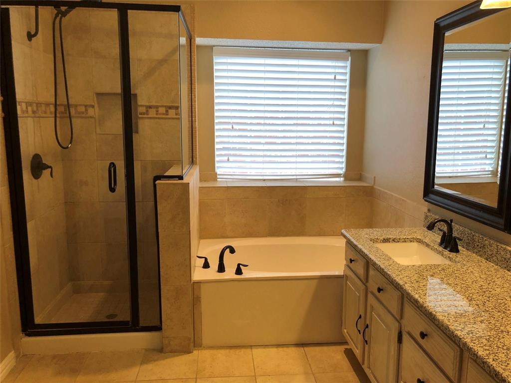 8301 Bells Street Frisco, TX 75035 - Photo 14 of 24 a bathroom with a granite countertop sink and a bathtub