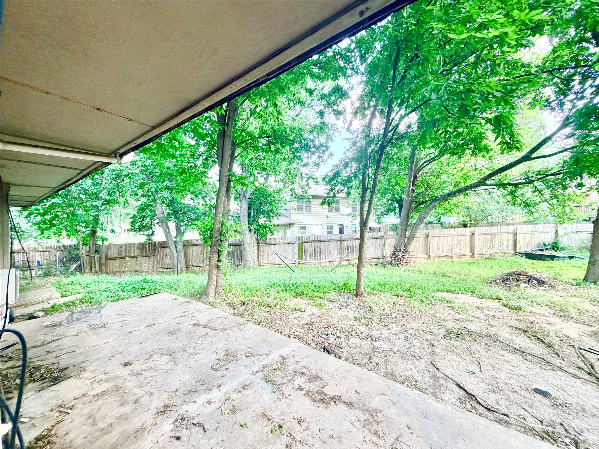 6257 Manor Road, Unit B Austin, TX 78723 - Photo 12 of 38 Expansive backyard featuring mature trees, partial privacy fencing, and a concrete patio