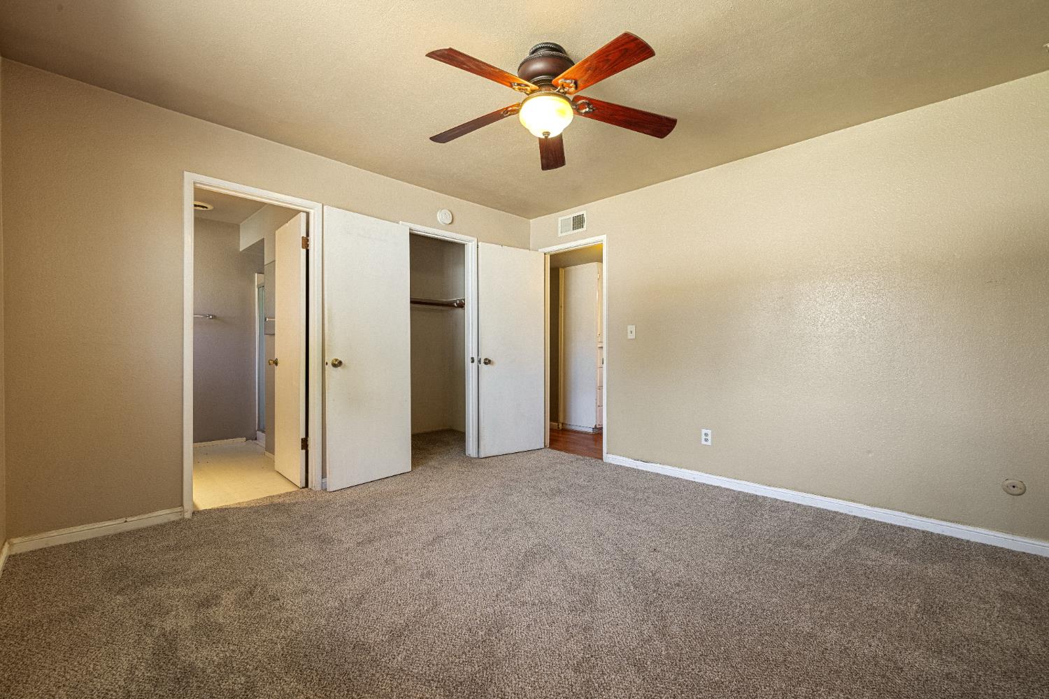 808 Cadillac Drive Modesto, CA 95351 - Photo 14 of 41 Primary bedroom with brand new carpet, a ceiling fan, a spacious closet, and ensuite bathroom