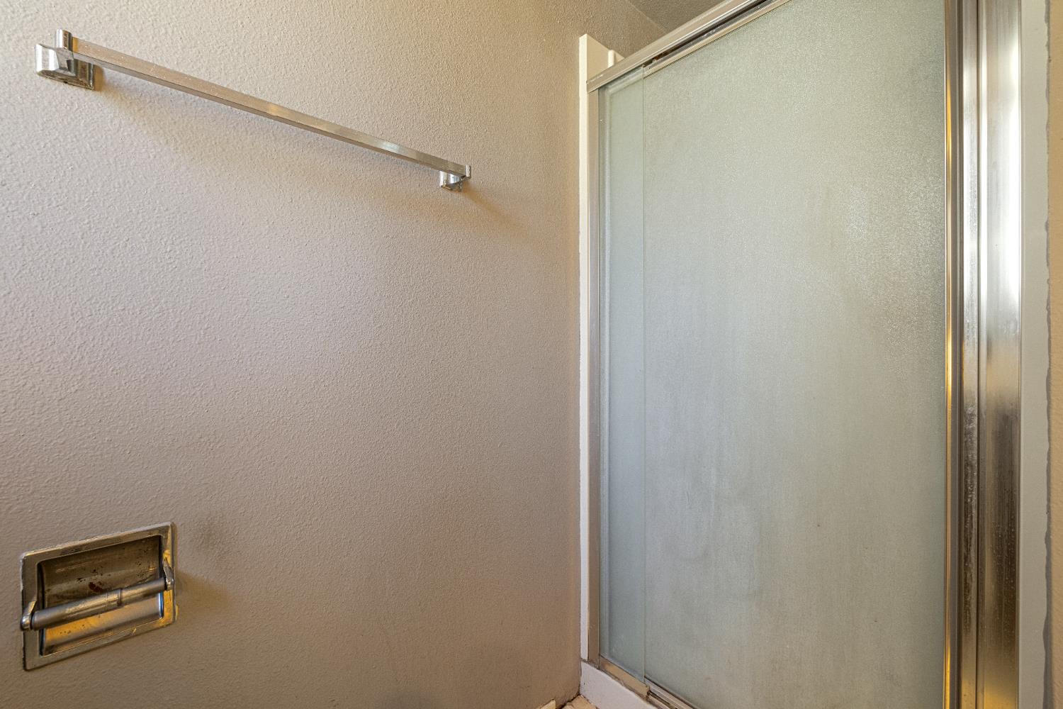 808 Cadillac Drive Modesto, CA 95351 - Photo 16 of 41 Full primary bathroom featuring a stall shower and a textured wall