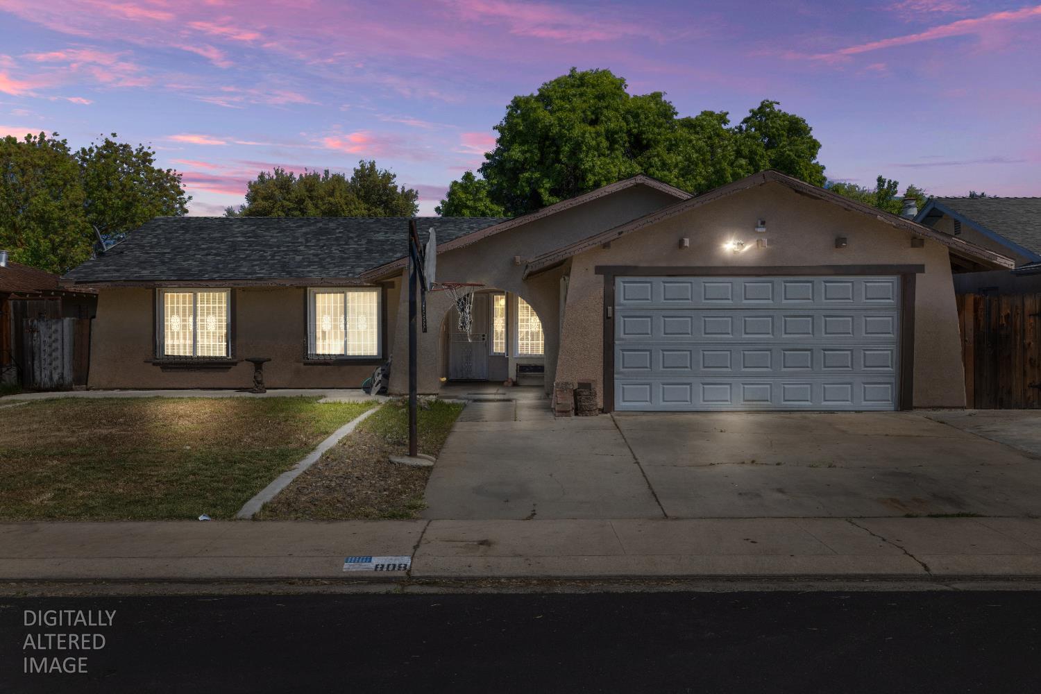 808 Cadillac Drive Modesto, CA 95351 - Photo 2 of 41 The lights on in the house and the sunset are digitally altered.