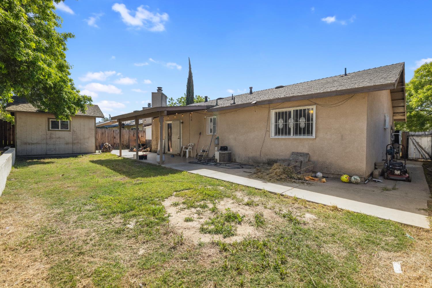 808 Cadillac Drive Modesto, CA 95351 - Photo 25 of 41 Rear view of property featuring a patio area, a fenced backyard, stucco siding, a shingled roof, and a storage unit