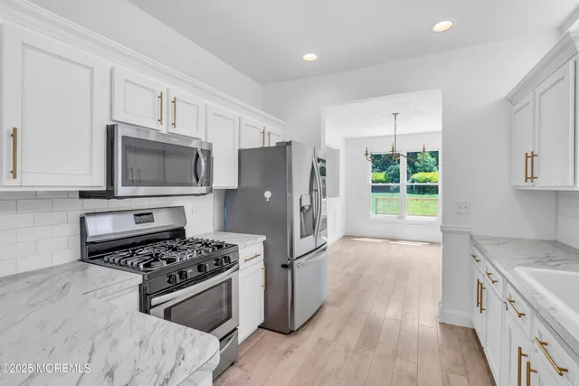 a kitchen with granite countertop a refrigerator stove and sink