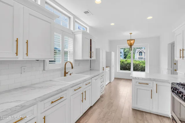 a kitchen with stainless steel appliances a stove a microwave and white cabinets