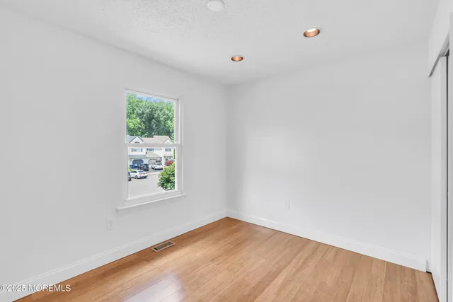 a view of room with window and wooden floor