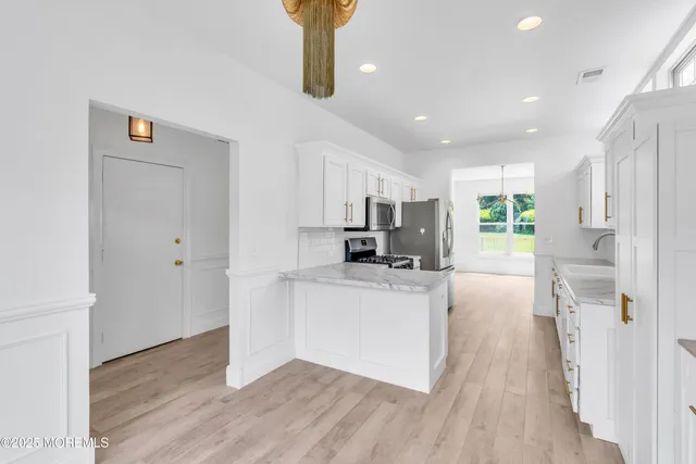 a kitchen with stainless steel appliances a refrigerator and a stove top oven