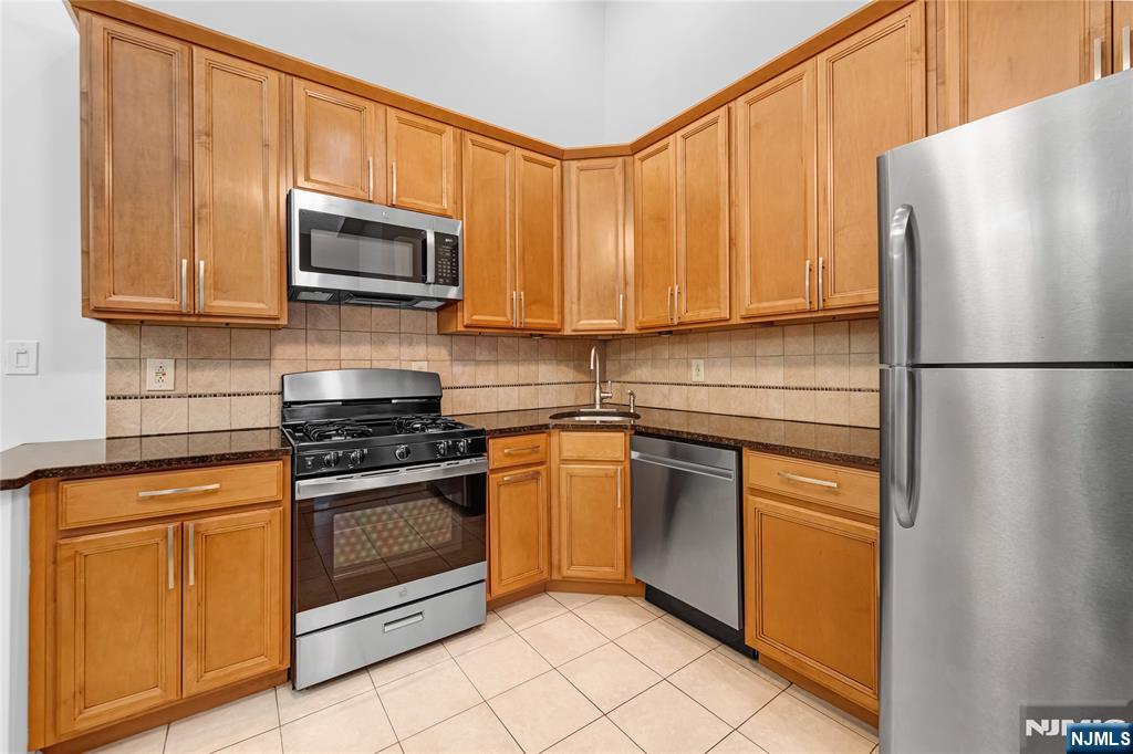 581 Holly Court Mahwah, NJ 07430 - Photo 7 of 21 a kitchen with stainless steel appliances granite countertop a refrigerator stove a sink and a microwave