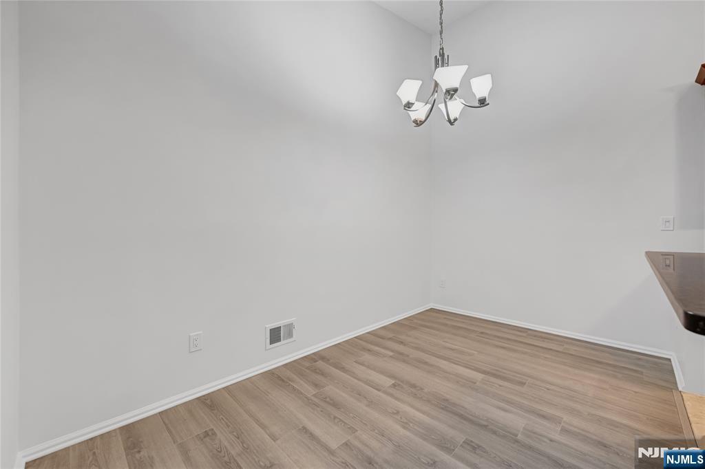 581 Holly Court Mahwah, NJ 07430 - Photo 9 of 21 a room with a chandelier and wooden floor