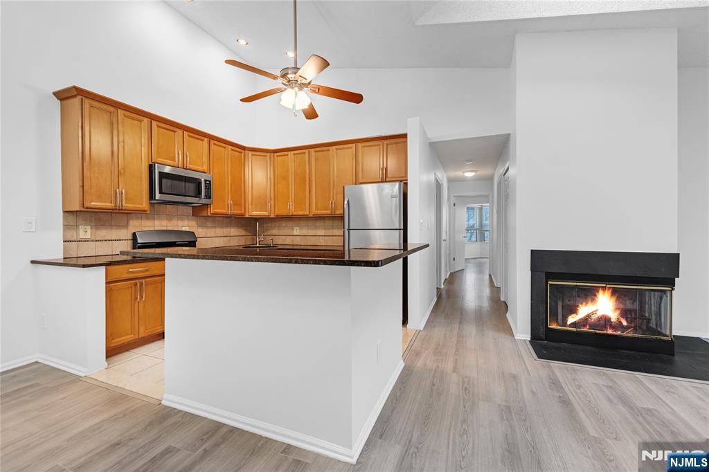 581 Holly Court Mahwah, NJ 07430 - Photo 10 of 21 a kitchen with granite countertop a refrigerator a stove top oven a sink and dishwasher with wooden floor