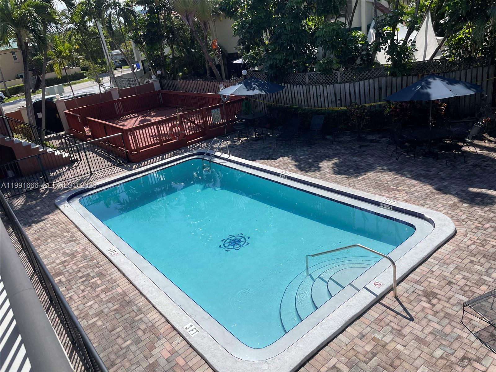 1405 Miami Road, Unit 23 Fort Lauderdale, FL 33316 - Photo 19 of 20 a view of a backyard with chairs and a small cabin
