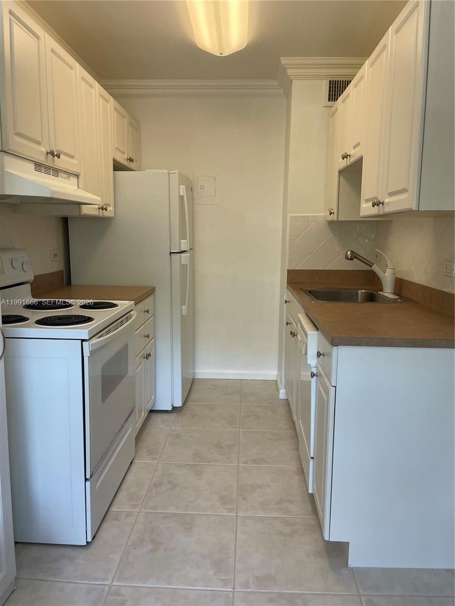 1405 Miami Road, Unit 23 Fort Lauderdale, FL 33316 - Photo 4 of 20 a kitchen with stainless steel appliances a stove a sink and a refrigerator