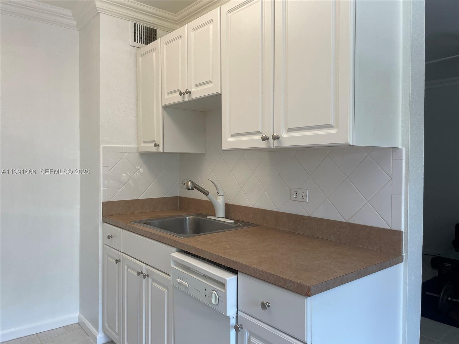 1405 Miami Road, Unit 23 Fort Lauderdale, FL 33316 - Photo 6 of 20 a kitchen with granite countertop white cabinets and a sink