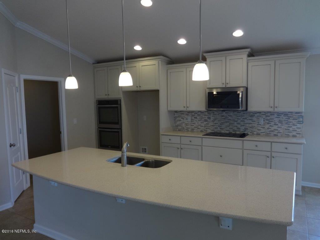 316 Crescent Key Drive St. Augustine, FL 32086 - Photo 30 of 45 a kitchen with kitchen island granite countertop a sink a refrigerator and chairs
