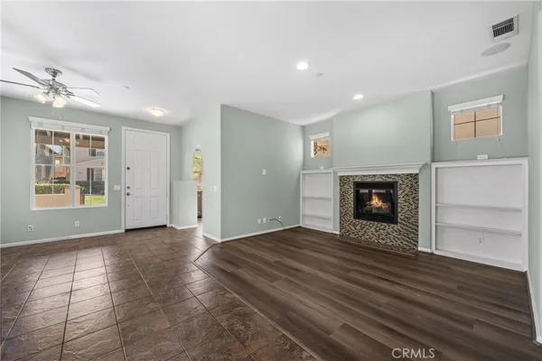 an empty room with windows and fireplace