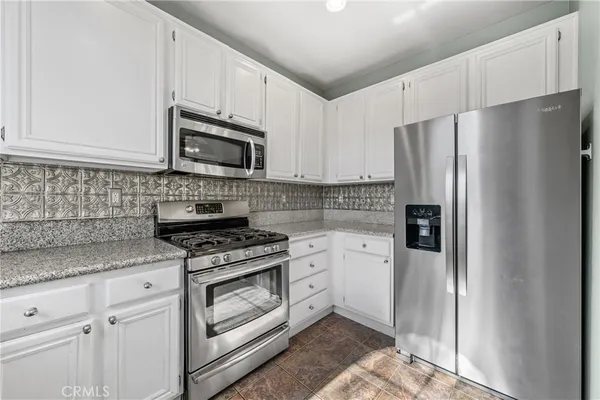 a kitchen with cabinets stainless steel appliances and a counter space