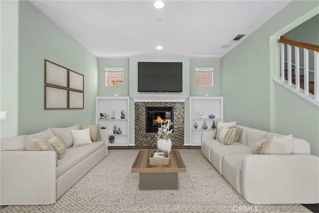 25 Amy Way Ladera Ranch, CA 92694 - Photo 3 of 47 a living room with furniture a flat screen tv and a fireplace