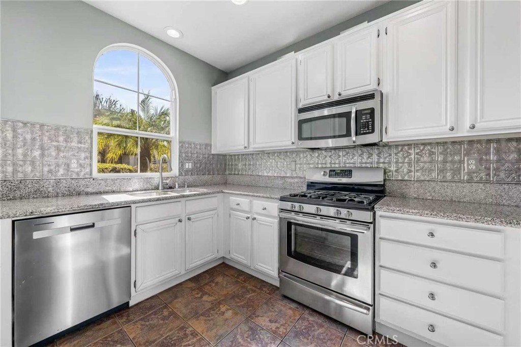 25 Amy Way Ladera Ranch, CA 92694 - Photo 9 of 47 a kitchen with granite countertop white cabinets stainless steel appliances a sink and a window