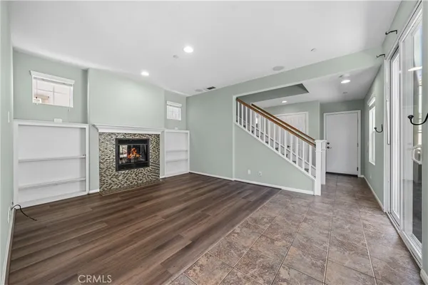 a view of empty room with fireplace and wooden floor