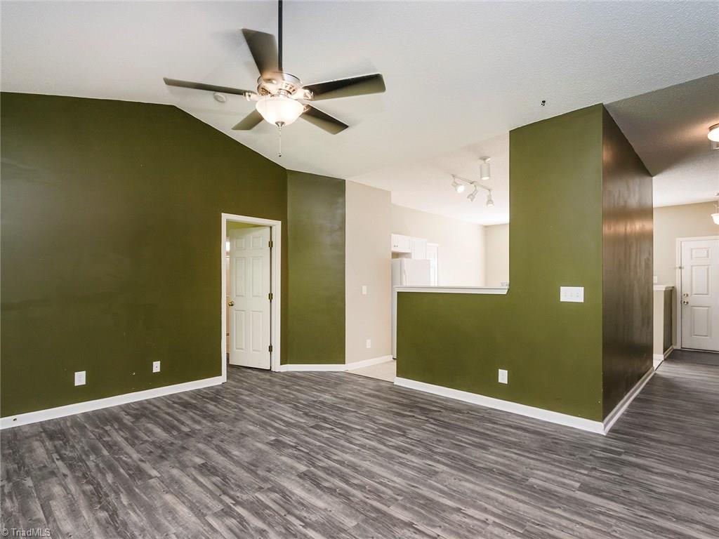 4705 Fewell Road Greensboro, NC 27405 - Photo 9 of 23 The living room offers great space. Notice the ceiling fans and vaulted ceilings.