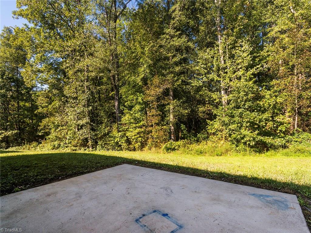 4705 Fewell Road Greensboro, NC 27405 - Photo 18 of 23 The backyard looks out into a wooded area.