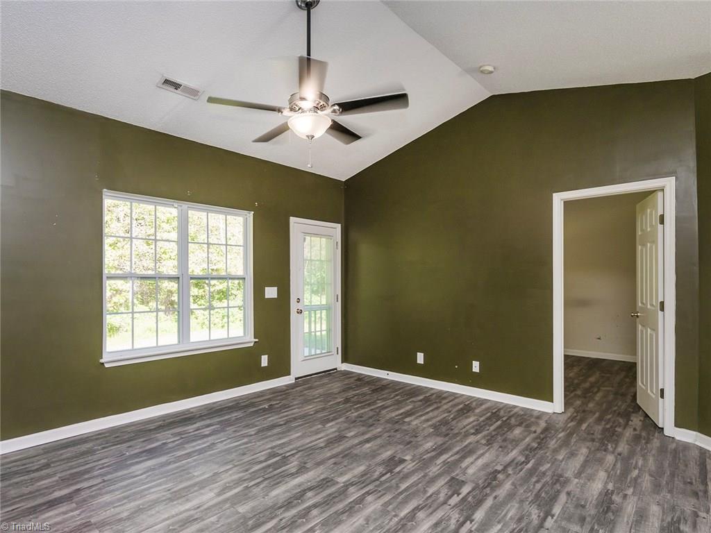 4705 Fewell Road Greensboro, NC 27405 - Photo 4 of 23 The living room is a great spacious room with vaulted ceilings and new flooring.