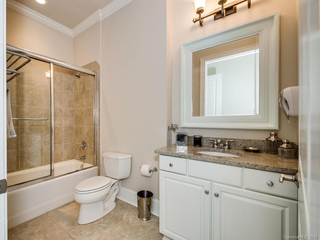 626 Queens Road, Unit 304 Charlotte, NC 28207 - Photo 7 of 24 a bathroom with a toilet sink vanity and mirror