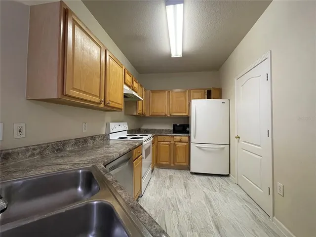 a kitchen with a refrigerator sink and cabinets