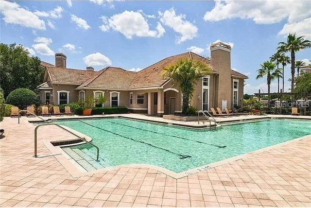 a view of a white house with a yard table and chairs
