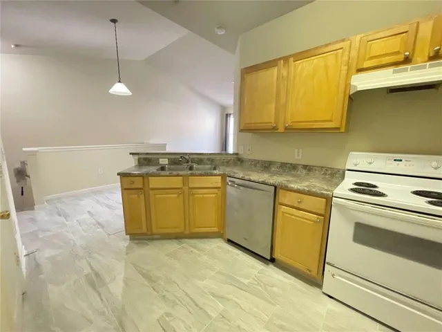 a kitchen with a stove sink and cabinets