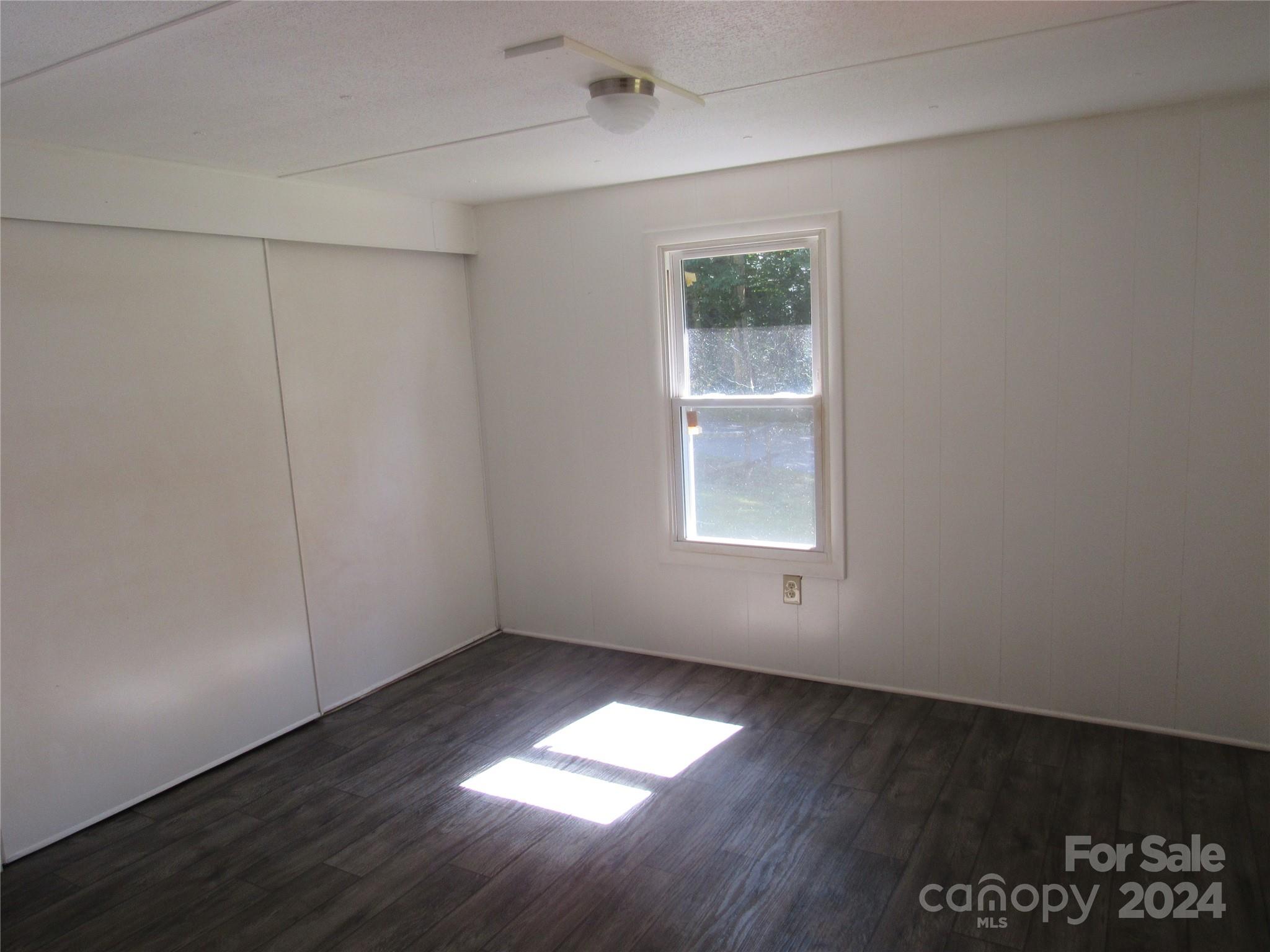 664 Woodfin Road Sylva, NC 28779 - Photo 6 of 34 an empty room with wooden floor and windows