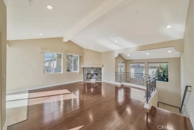 a view of empty room with wooden floor and fireplace
