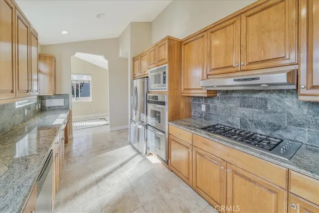 a large kitchen with kitchen island a large window a sink and cabinets
