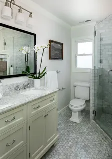 a bathroom with a granite countertop toilet sink and mirror