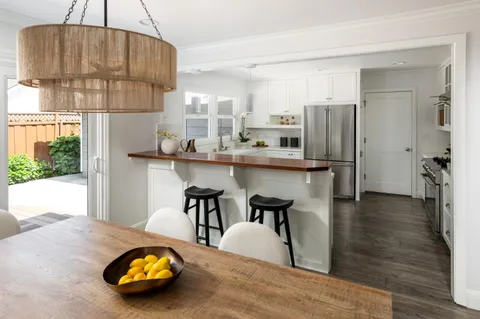 a kitchen with stainless steel appliances a table chairs and refrigerator