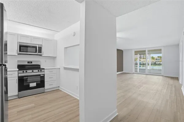 a kitchen with stainless steel appliances a stove top oven a sink and a refrigerator