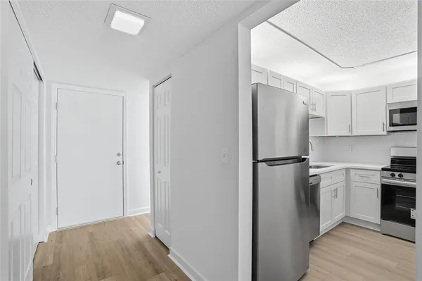 a kitchen with a refrigerator a stove top oven and white kitchen island