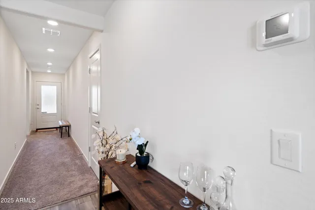 a living room with stainless steel appliances furniture a fireplace kitchen view and a chandelier