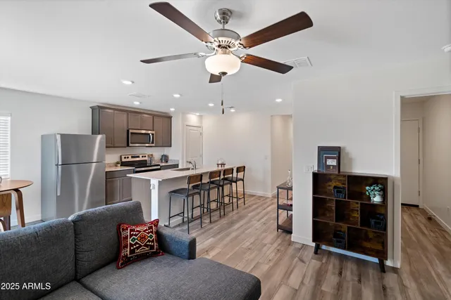 a kitchen with a dining table chairs and refrigerator