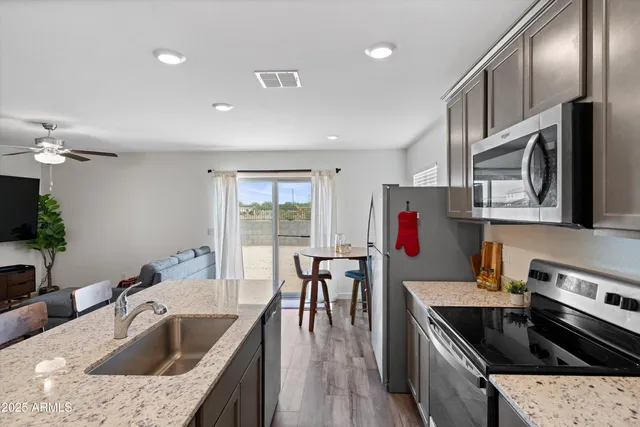 a kitchen with granite countertop stainless steel appliances and wooden cabinets