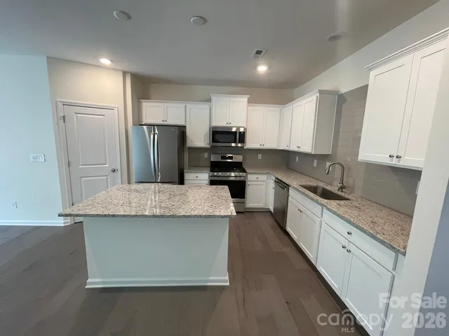 a kitchen with kitchen island a sink stove and refrigerator