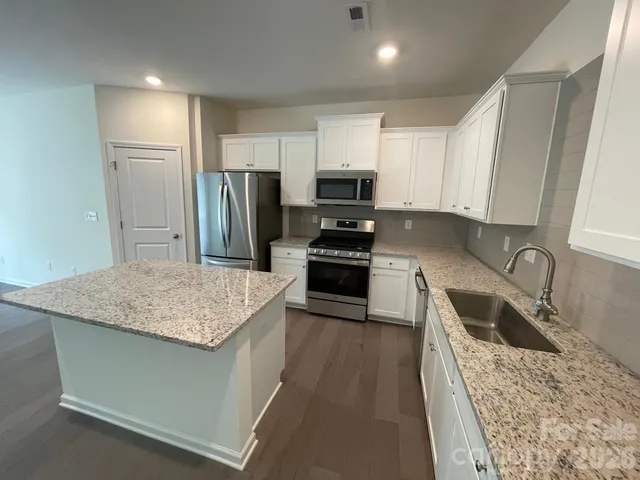 a view of kitchen with kitchen island microwave and stove