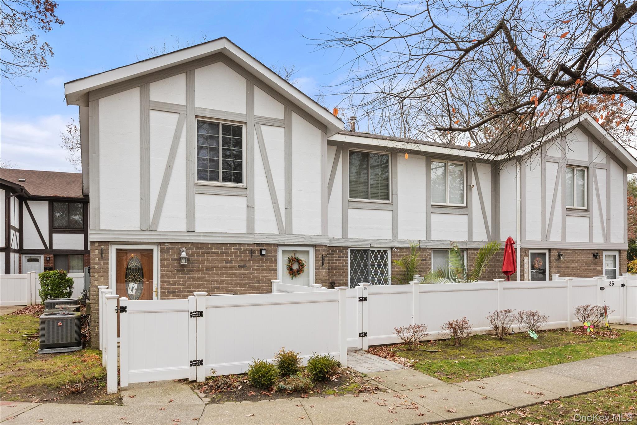 View of front facade featuring a gate, brick siding, and a fenced front yard