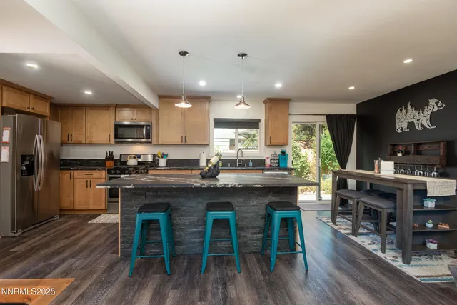 a kitchen with kitchen island granite countertop wooden floors and wooden cabinets