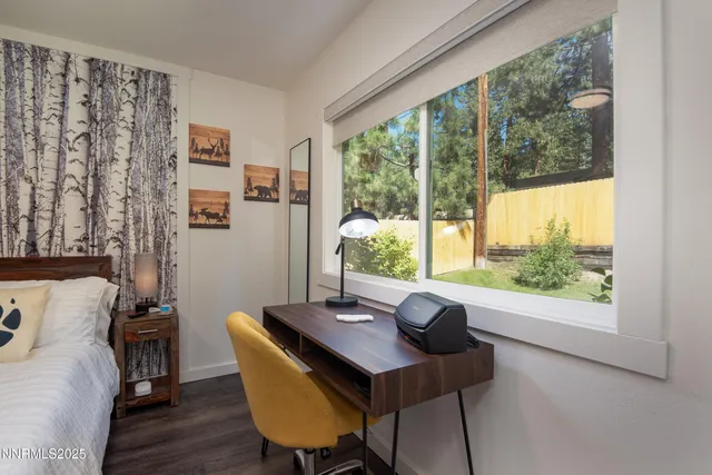 a view of a workspace with furniture and a window