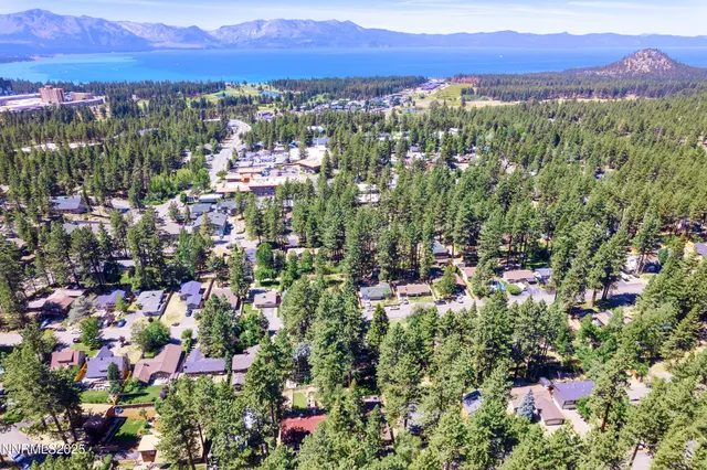 an aerial view of residential house with outdoor space and trees all around