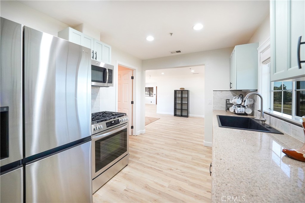2165 Lilac Road Ramona, CA 92065 - Photo 9 of 49 a kitchen with stainless steel appliances a refrigerator stove and sink