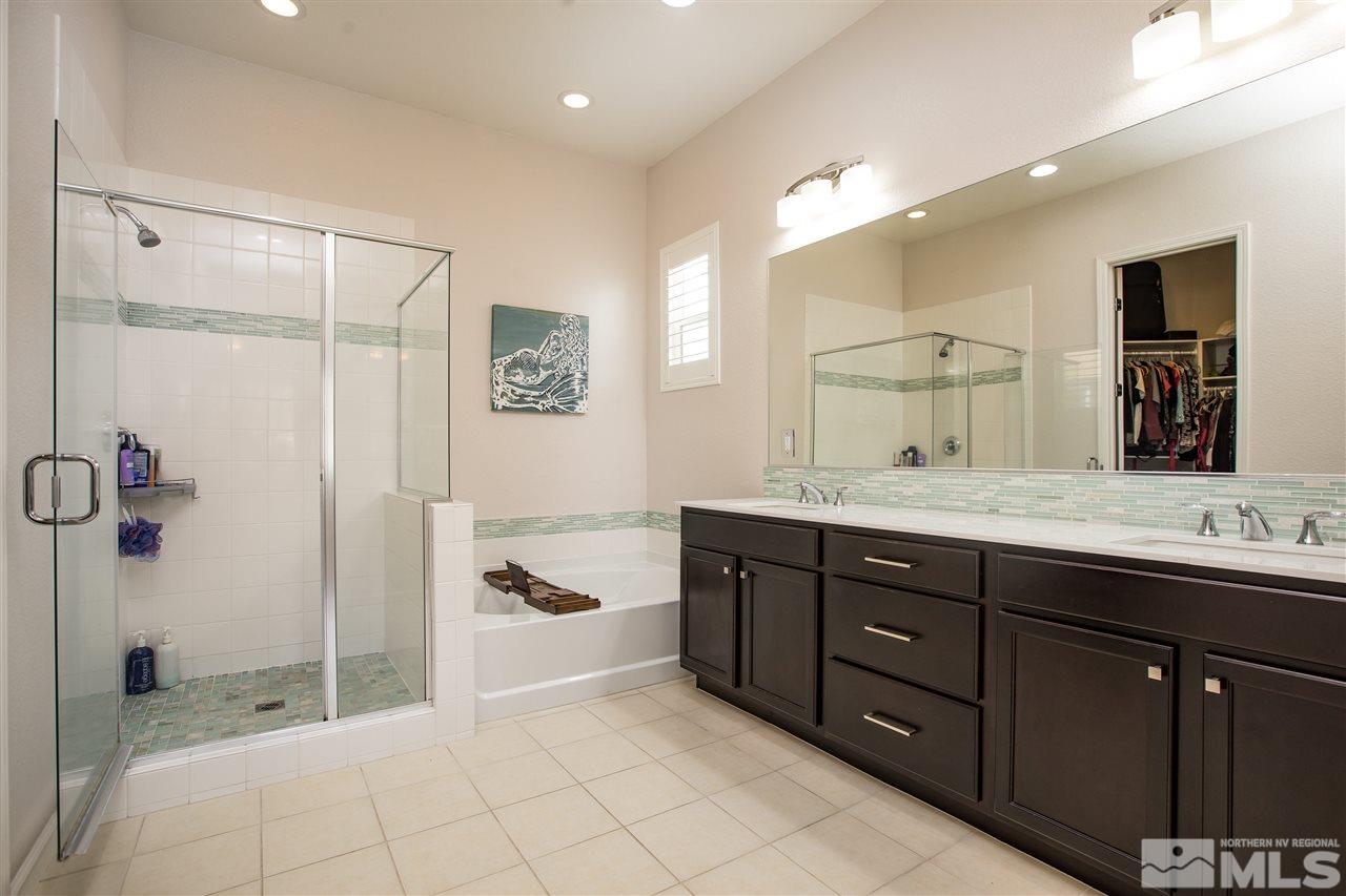 3045 Show Jumper Lane Reno, NV 89521 - Photo 10 of 22 a bathroom with a tub a sink double vanity and a mirror