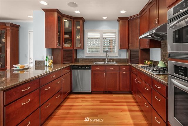 a large kitchen with stainless steel appliances granite countertop a sink and a stove